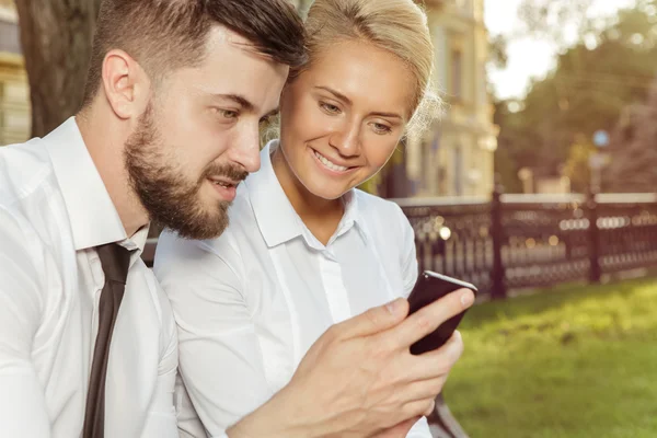 Dois colegas discutindo algo em um celular — Fotografia de Stock