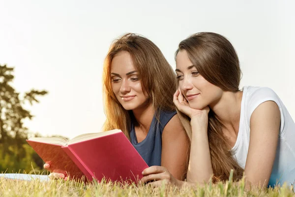 Dos hermosas chicas leyendo libro en el parque — Foto de Stock