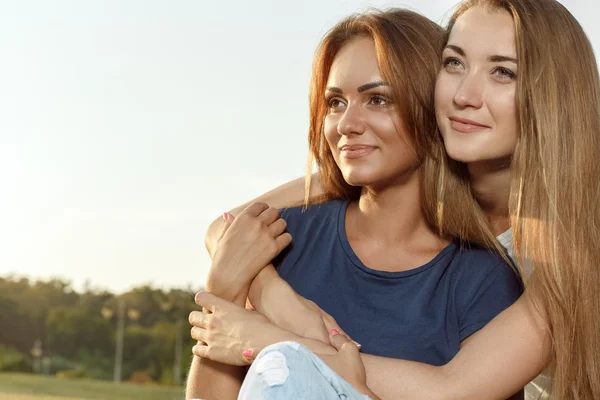 Two attractive girlfriends in the park — Stock Photo, Image