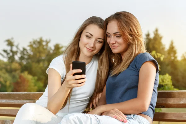 Two beautiful girls resting on the bench — Stock Photo, Image