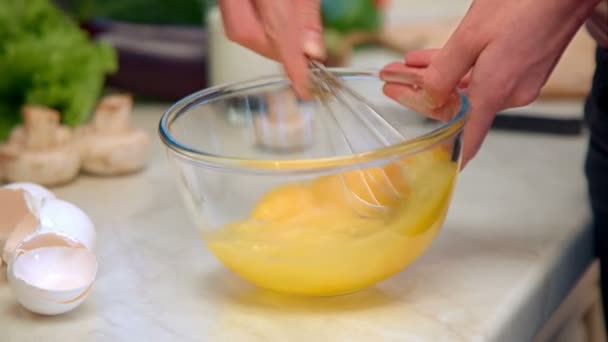 Ama de casa batiendo huevos en un tazón — Vídeo de stock