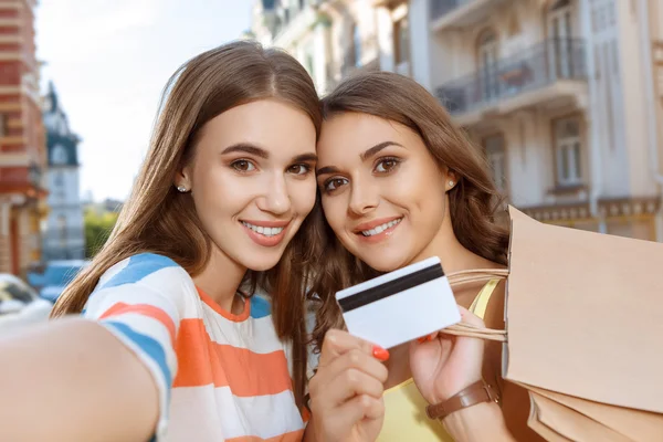 Kaksi ystävää tekee selfie kanssa ostoskassit kuvapankkikuva