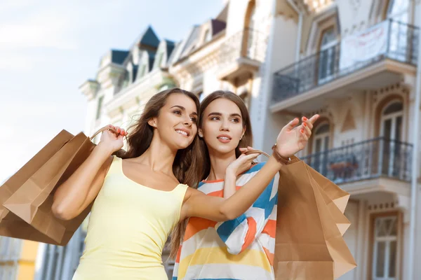 Kaksi tyttöä kävelee kaupungissa aikana ostoksia tekijänoikeusvapaita valokuvia kuvapankista