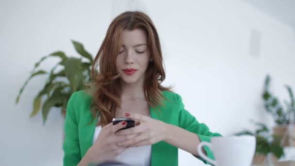 Молодая женщина пользуется телефоном в кафе — стоковое видео