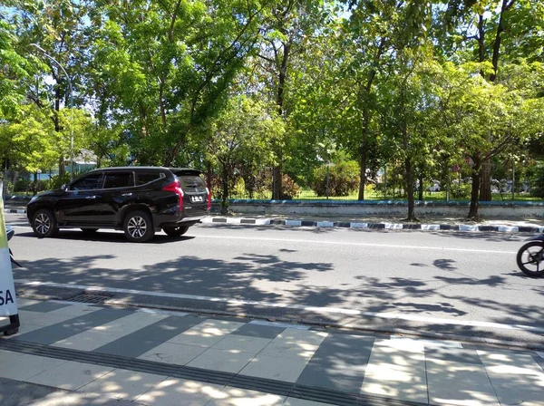 2021年7月4日 印度尼西亚塞马朗 一条城市街道 旁边有汽车和摩托车司机 还有茂密的树木 — 图库照片