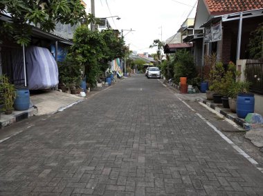 Endonezya 'da sakin bir ev. Evin içinde ve dışında park edilmiş çeşitli arabalar var.