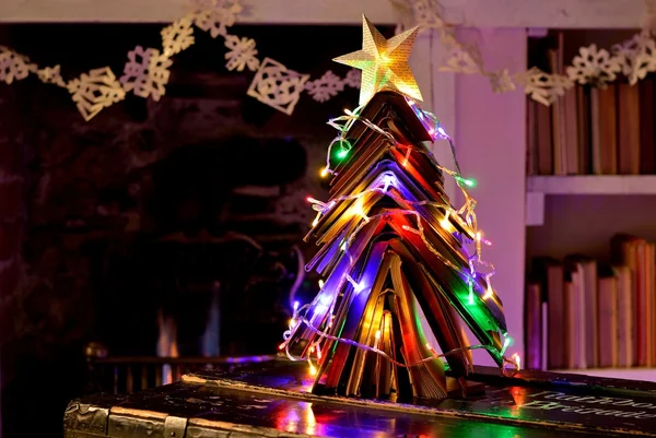 Libros vintage Árbol de Navidad, cadena de copos de nieve y fuego abierto . — Foto de Stock