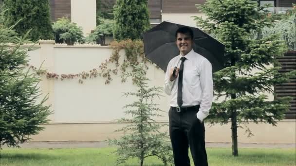 Conteúdo Empresário com guarda-chuva sorrindo na chuva de verão — Vídeo de Stock