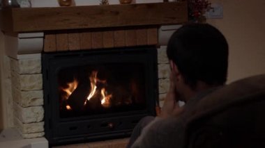 Genç adam bir şömine iletişim kavramı önünde bir aramayı cevaplama