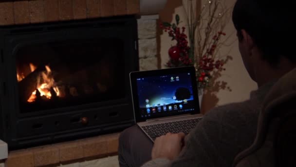 Ο άνθρωπος χρησιμοποιεί Skype σε ένα φορητό υπολογιστή μπροστά από ένα τζάκι επικοινωνιακού Concept της Dunlopillo — Αρχείο Βίντεο
