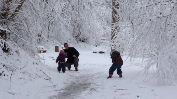 Mann und zwei kleine Mädchen spielen im Schnee Familienkonzept — Stockvideo