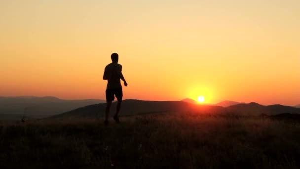 Ung Man att höja händerna på en solnedgång framgång befruktning — Stockvideo