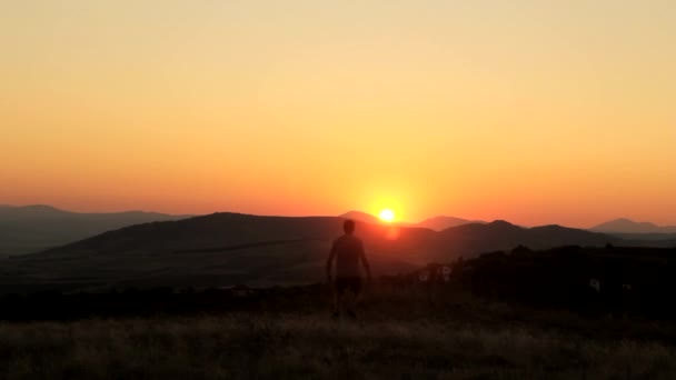 Joven adoración en un hermoso atardecer — Vídeo de stock