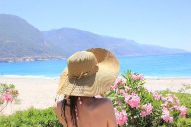 Sahilde şapkalı bir kadın