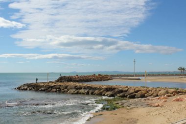 Torrevieja 'da deniz kenarı, taşlı iskele ve uzak manzara