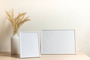 Portre çerçevesi ahşap masada kurumuş çiçeklerle süslenir.