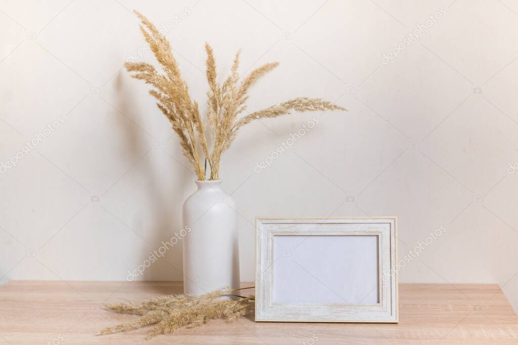 Portrait frame mock up with dried flowers on wooden table