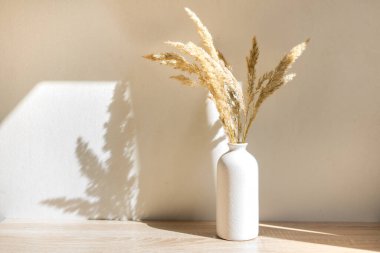 Portre çerçevesi ahşap masada kurumuş çiçeklerle süslenir.