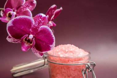 Renkli arka planda orkide çiçekli pembe banyo tuzu. Yüksek kalite fotoğraf