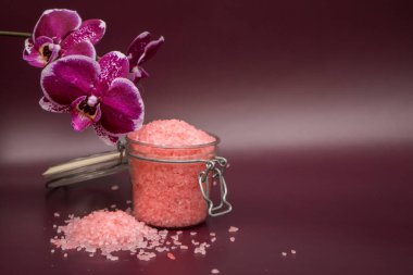 Renkli arka planda orkide çiçekli pembe banyo tuzu. Yüksek kalite fotoğraf