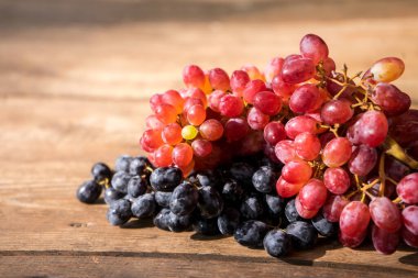 Tahta masadaki üzümler. Yapraklı taze kırmızı üzüm dalı. Yüksek kalite fotoğraf