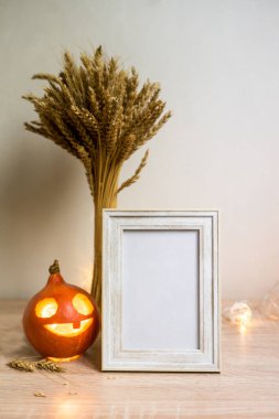 Portre çerçevesi ahşap masada kurumuş çiçek kabağı ile taklit edilir. Cadılar Bayramı