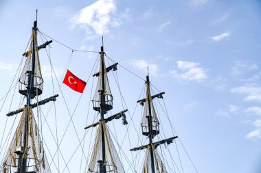 Gökyüzünde Türk bayrağı olan gemi direkleri.