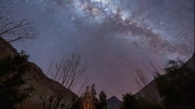 Şili 'deki Valle del Elqui dağları arasında kayan yıldızlarla dolu bir vadi üzerinde hareket halindeki bir Samanyolu' nun zaman kayması.