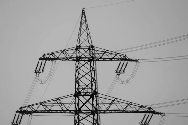 Черный Силуэт Верхней Части Электрического Столба Против Серого Безликого Неба — стоковое фото