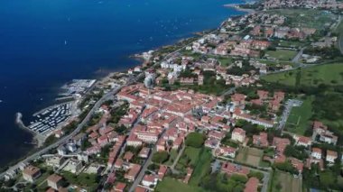 Deniz kenarında güneşli bir günde kıyı kasabası ve gemilerin çarpıcı manzarası. 