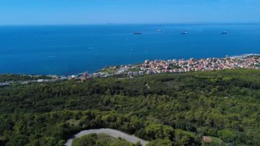 Deniz kenarında güneşli bir günde kıyı kasabası ve gemilerin çarpıcı manzarası. 