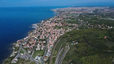 Deniz kenarında güneşli bir günde kıyı kasabası ve gemilerin çarpıcı manzarası. 