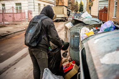 Poltava, Ukrayna - 18 Şubat 2016: iki genç erkekler diğer çöp geri dönüşüm için kağıt toplama. Ülkede enflasyon üç kez para maliyeti azalttı.
