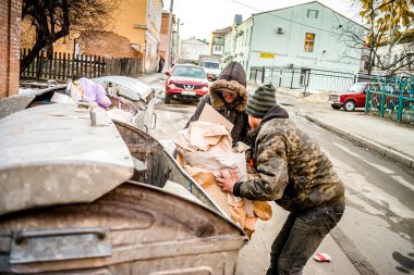 Poltava, Ukrayna - 18 Şubat 2016: iki genç erkekler diğer çöp geri dönüşüm için kağıt toplama. Ülkede enflasyon üç kez para maliyeti azalttı.