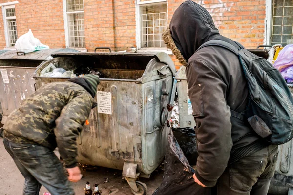 Полтава, Україна - 18 лютого 2016 року: двоє молодих людей поблизу сміття, збираючи паперу для переробки. Інфляції в країні дозволило знизити витрати на гроші три рази. — стокове фото