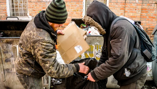 Полтава, Україна - 18 лютого 2016 року: двоє молодих людей поблизу сміття, збираючи паперу для переробки. Інфляції в країні дозволило знизити витрати на гроші три рази. — стокове фото