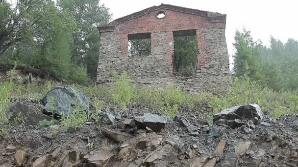 Wall of an abandoned stone house in the pouring rain — Stock Video