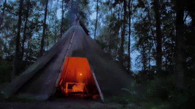 Rahat tipi'nde karanlık İskandinav ormanın içinde kavrulmuş et pişirme