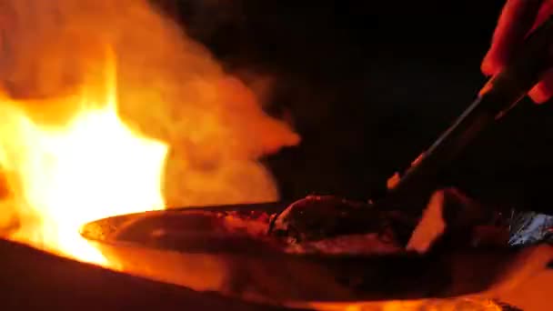 Uma faca escandinava é usada para transformar batatas fritas em manteiga usando uma frigideira de aço carbono diretamente em uma fogueira de acampamento aberto — Vídeo de Stock