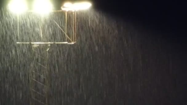 Projecteurs de stade la nuit lors d'une forte pluie . — Video