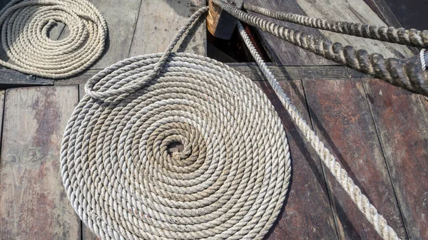 Curled up tarred hemp rope on viking ship deck — Stock Photo, Image