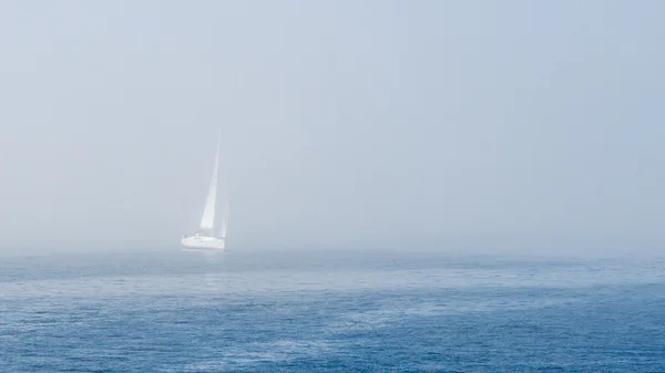 Mały jacht wypływających z mgły morza — Zdjęcie stockowe
