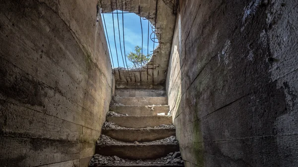 Olhando para o céu azul através de um buraco no concreto de um bunker — Fotografia de Stock