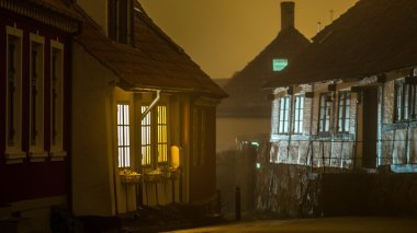 Bir eski Danimarka kasabasında Sandvig siste pencerelerden parlayan ışık