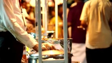 Tamil Nadu güneyde Hint bir düğünde insanlar bir sıra yemekleri sunan garsonlar