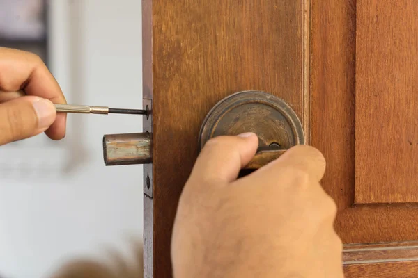 Cerrajero en la puerta de madera para la reparación — Foto de Stock