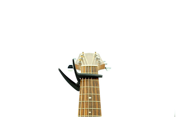 Capo on neck of guitar , isolate on white background