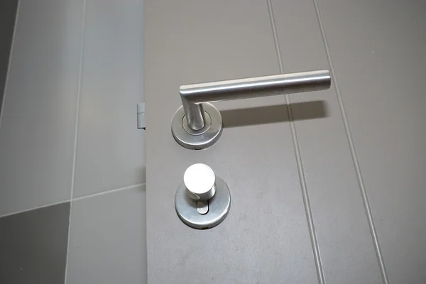 Silberner Knopf und graue Tür — Stockfoto