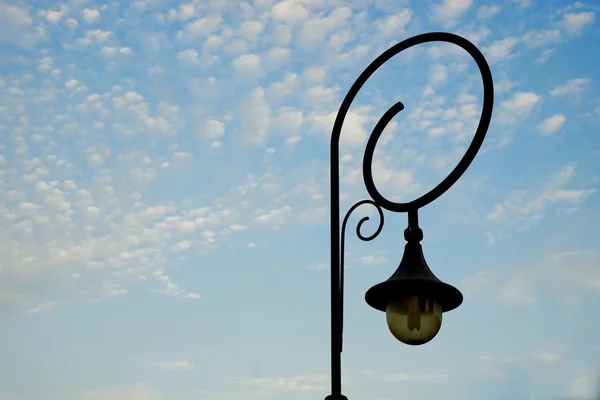 Old black lamp on blue sky — Stock Photo, Image