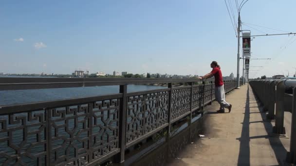 Man Walks Bridge Looks River — Stockvideo